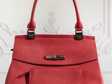 a red leather handbag sitting on a wooden table