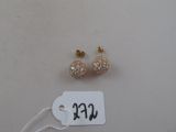 deux paires de boucles d'oreilles avec une étiquette de prix posées sur une table blanche