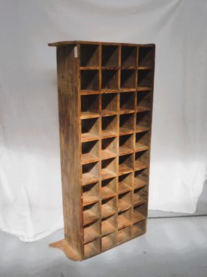 un vieux casier à vin en bois sur lequel sont posées de nombreuses bouteilles de vin