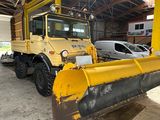 une grande déneigeuse jaune garée dans un garage