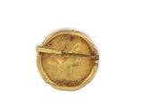 an image of a gold broochle with a woman ' s face on it