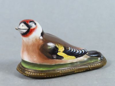a figurine of a bird sitting on the ground