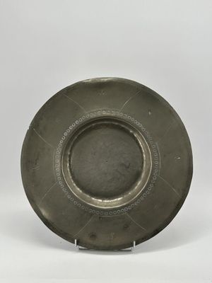 une assiette en argent antique avec un motif circulaire sur le bord