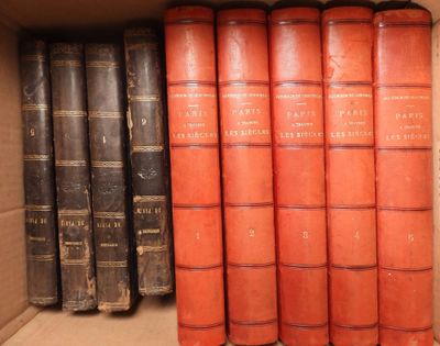 several old books are stacked on a shelf in a box
