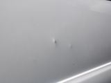 a white car with a hole in the side of it