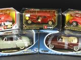 four toy cars are in a box on a black surface