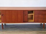 a wooden sideboard with two open shelves and two doors