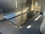 un banc en métal dans une pièce dont les fenêtres sont équipées de stores