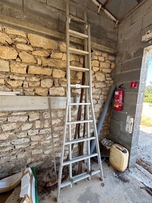 une échelle appuyée contre un mur de briques dans une pièce