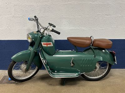 a green motorcycle that is parked in a garage