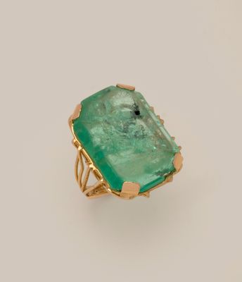 Gros plan sur une bague ornée d'une pierre verte