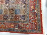 an antique persian rug on a white surface with a red background