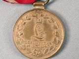 a gold medal with a red ribbon around it