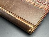 an old book sitting on top of a table next to a pair of scissors