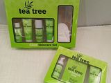 two boxes of tea tree skin care products sitting on a bed