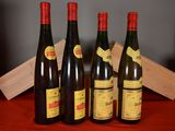 six bottles of wine are lined up on a red table