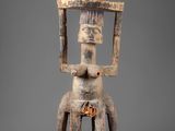 a statue of a man sitting on top of a wooden base