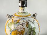 a vase with a painting on it sitting on a table