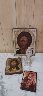 une petite statue de Jésus à côté d'une image de Jésus