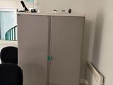 une pièce équipée d'un bureau, d'une chaise et d'une armoire