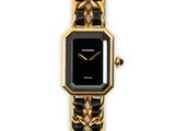 a close up of a gold and black watch on a white background