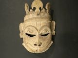 un gros plan d'un masque sculpté sur une surface noire