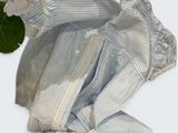 a blue and white striped shirt and a pair of white pants