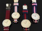 four different styles of watches are displayed on a black surface