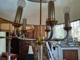 a chandelier in the middle of a room with chairs and a table