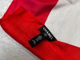 a close up of a red and white flag with a black tag on it