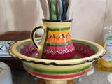 a colorful cup with scissors in it sitting on a counter