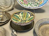 many plates and bowls on the table with spoons and spoons