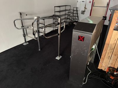 une petite chambre avec un lit en métal et un réfrigérateur à l'intérieur
