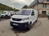 une petite camionnette blanche garée devant un bâtiment