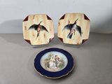 deux assiettes avec des oiseaux peints dessus, posées sur une table
