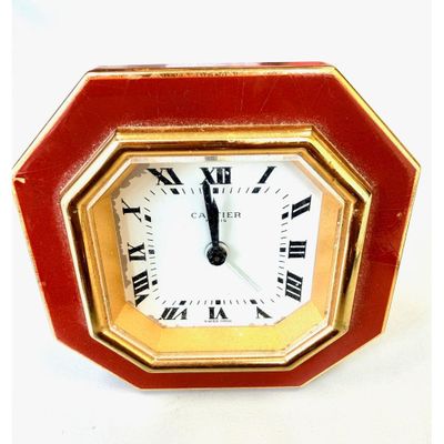 CARTIER. (Vers 1980). Pendulette réveil en métal doré et laq…