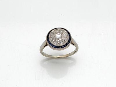 gros plan d'une bague en diamant et saphir sur une surface blanche