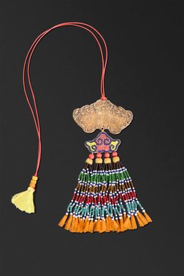 un gros plan d'un collier orné d'un pompon sur fond noir