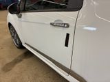 a white car parked in a garage with its door open