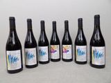 six bouteilles de vin sont alignées sur une table