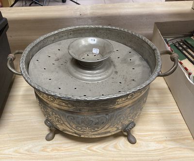 a large metal pot with a lid on a wooden table