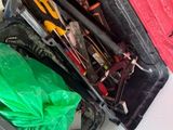 une valise rouge contenant des outils, posée par terre
