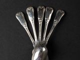 a silver spoon and spoon rest on a black surface