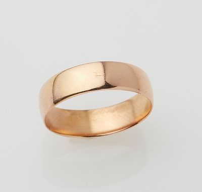 a gold wedding ring on a white background