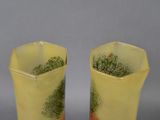 pair of yellow vases with trees on them on a gray surface