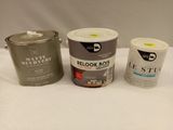 two cans of paint and a can of paint sitting on a table