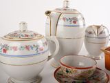 many different types of teapots and saucers on the table