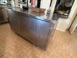 a large stainless steel kitchen island in the middle of a kitchen