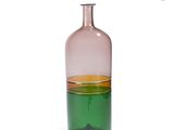 a green and pink glass bottle with a yellow top