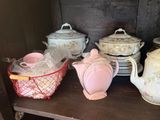 many teapots and cups on a shelf in a room